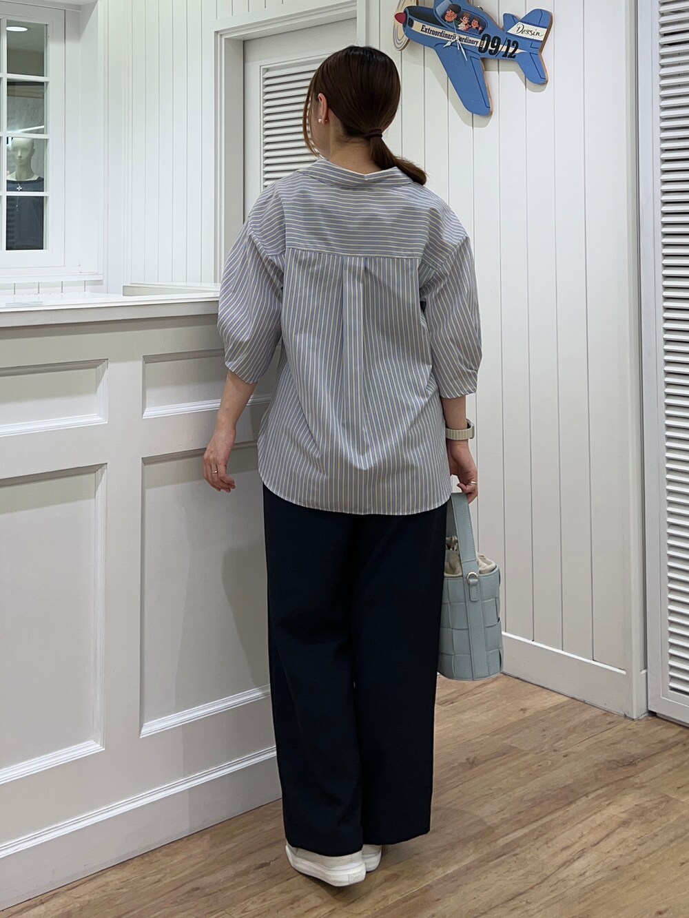 イエロー系のシャツ/ブラウス、ブルー系のその他パンツ、ブルー系のショルダーバッグを着用したレディースの春コーディネートの3枚目の写真