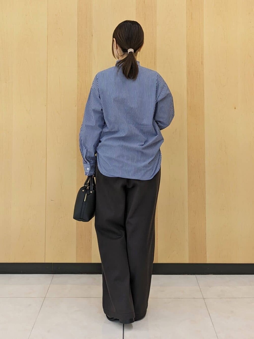 ブルー系のシャツ/ブラウス、ブラウン系のその他パンツ、ブラック系のショルダーバッグを着用したレディースの冬コーディネートの3枚目の写真