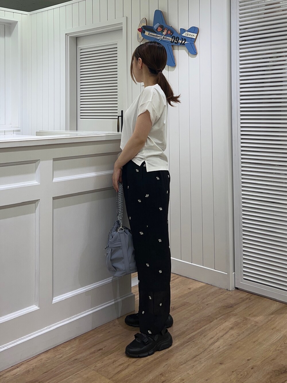 ホワイト系のTシャツ/カットソー、ブラック系のその他パンツ、ブルー系のショルダーバッグを着用したレディースの夏コーディネートの2枚目の写真