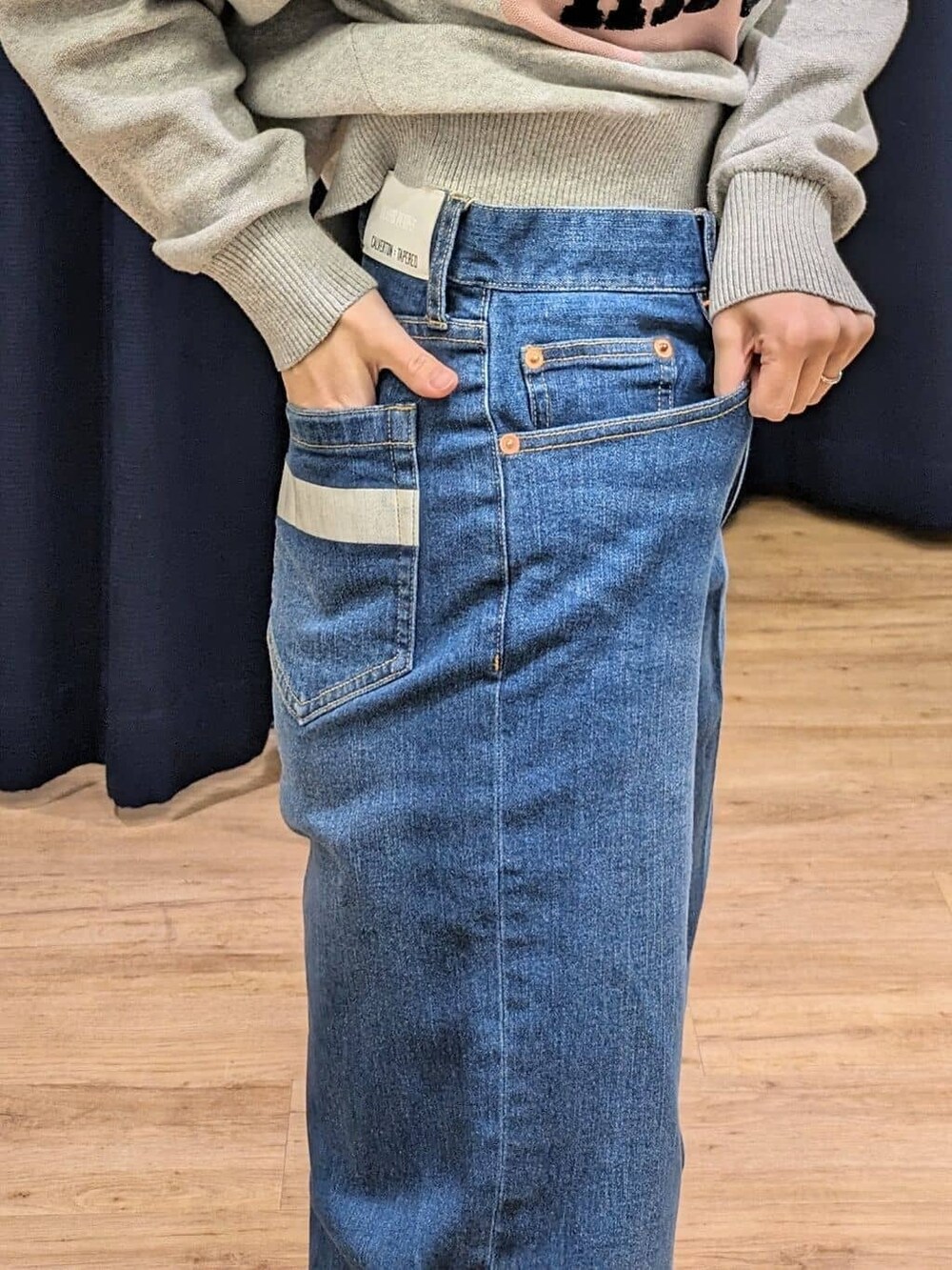 グレー系のニット/セーター、ブルー系のデニムパンツ、イエロー系のトートバッグを着用したレディースの冬コーディネートの6枚目の写真