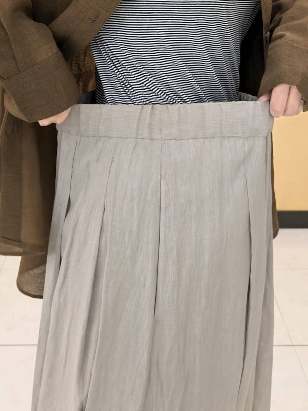ブラウン系のシャツ/ブラウス、ベージュ系のその他パンツ、ベージュ系のトートバッグを着用したレディースの秋コーディネートの6枚目の写真