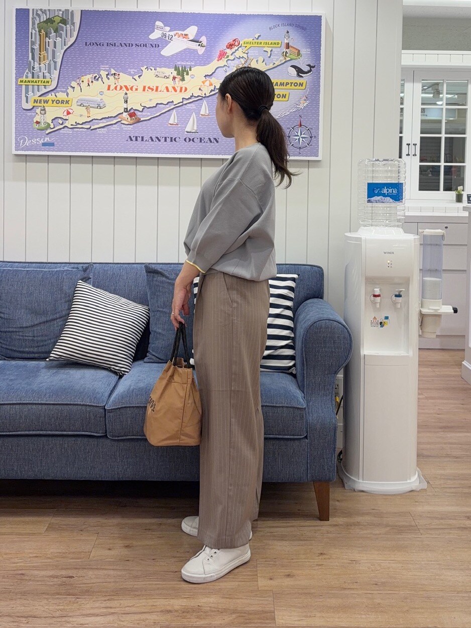 グレー系のニット/セーター、ブラウン系のその他パンツ、イエロー系のトートバッグを着用したレディースの夏コーディネートの2枚目の写真