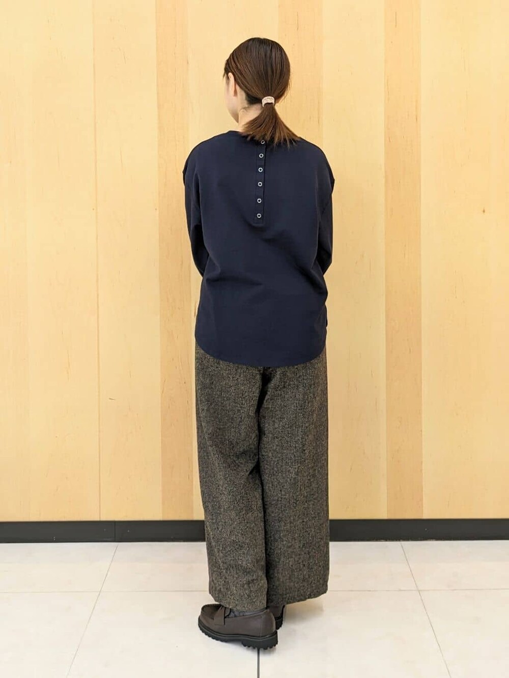 ブルー系のTシャツ/カットソー、ブラウン系のその他パンツ、レッド系のトートバッグを着用したレディースの秋コーディネートの3枚目の写真
