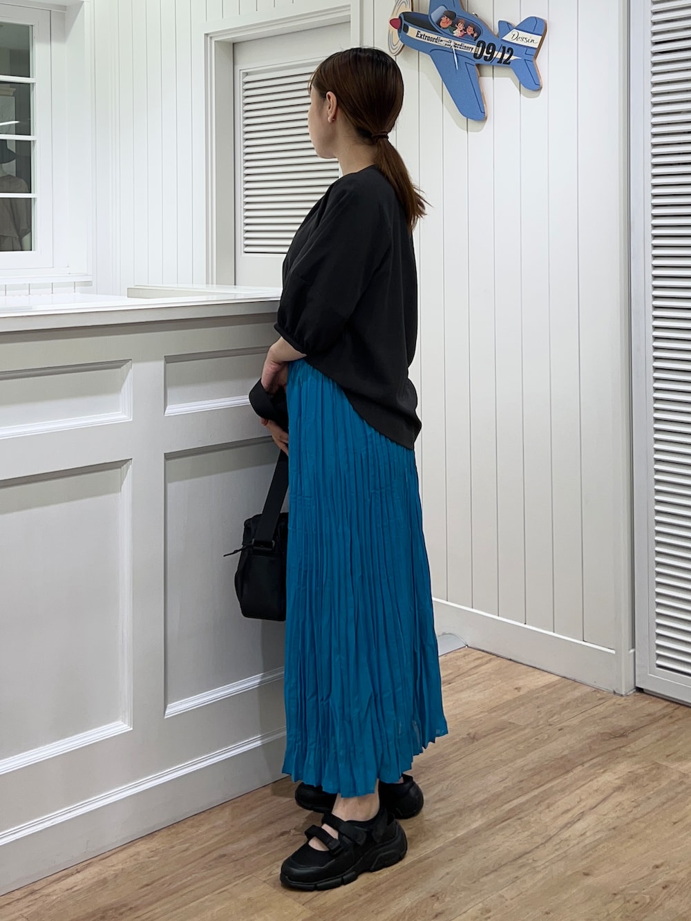 グレー系のシャツ/ブラウス、ブルー系のスカート、ブラック系のショルダーバッグを着用したレディースの春コーディネートの2枚目の写真