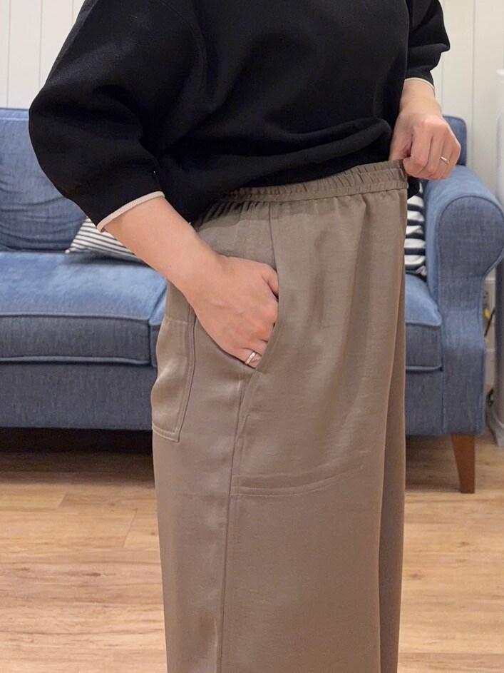 ブラック系のニット/セーター、ベージュ系のその他パンツ、ブラック系のトートバッグを着用したレディースの夏コーディネートの6枚目の写真