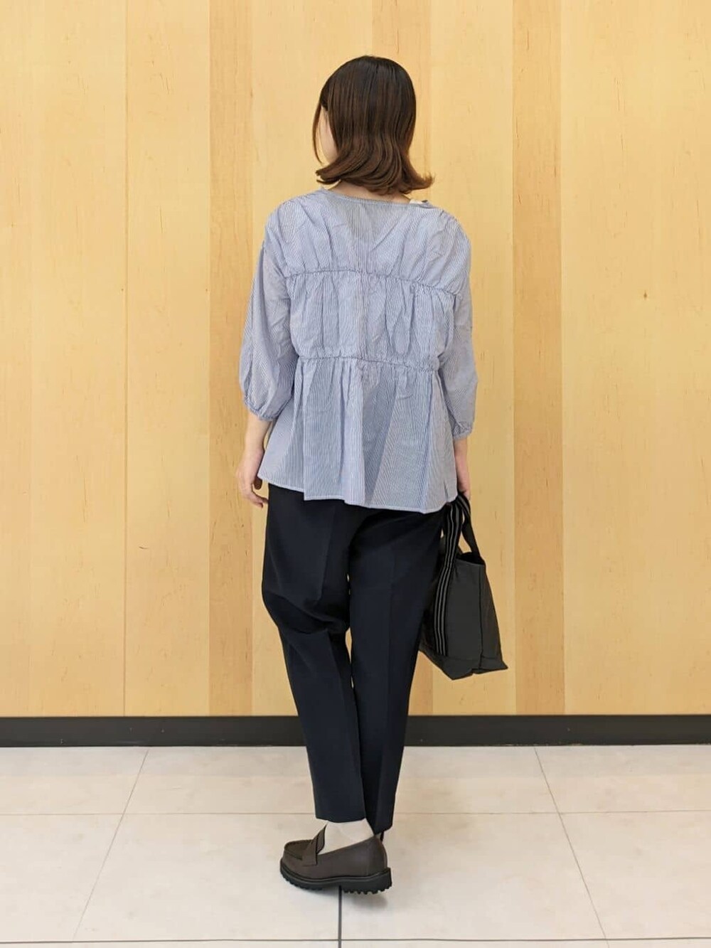 ブルー系のシャツ/ブラウス、ブルー系のその他パンツ、グレー系のトートバッグを着用したレディースの秋コーディネートの3枚目の写真