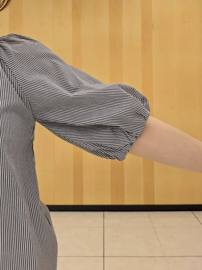 ベージュ系のシャツ/ブラウス、イエロー系のスカート、ベージュ系のトートバッグを着用したレディースの夏コーディネートの5枚目の写真