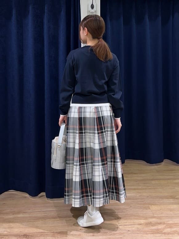 ブルー系のニット/セーター、レッド系のスカート、シルバー系のショルダーバッグを着用したレディースの春コーディネートの3枚目の写真