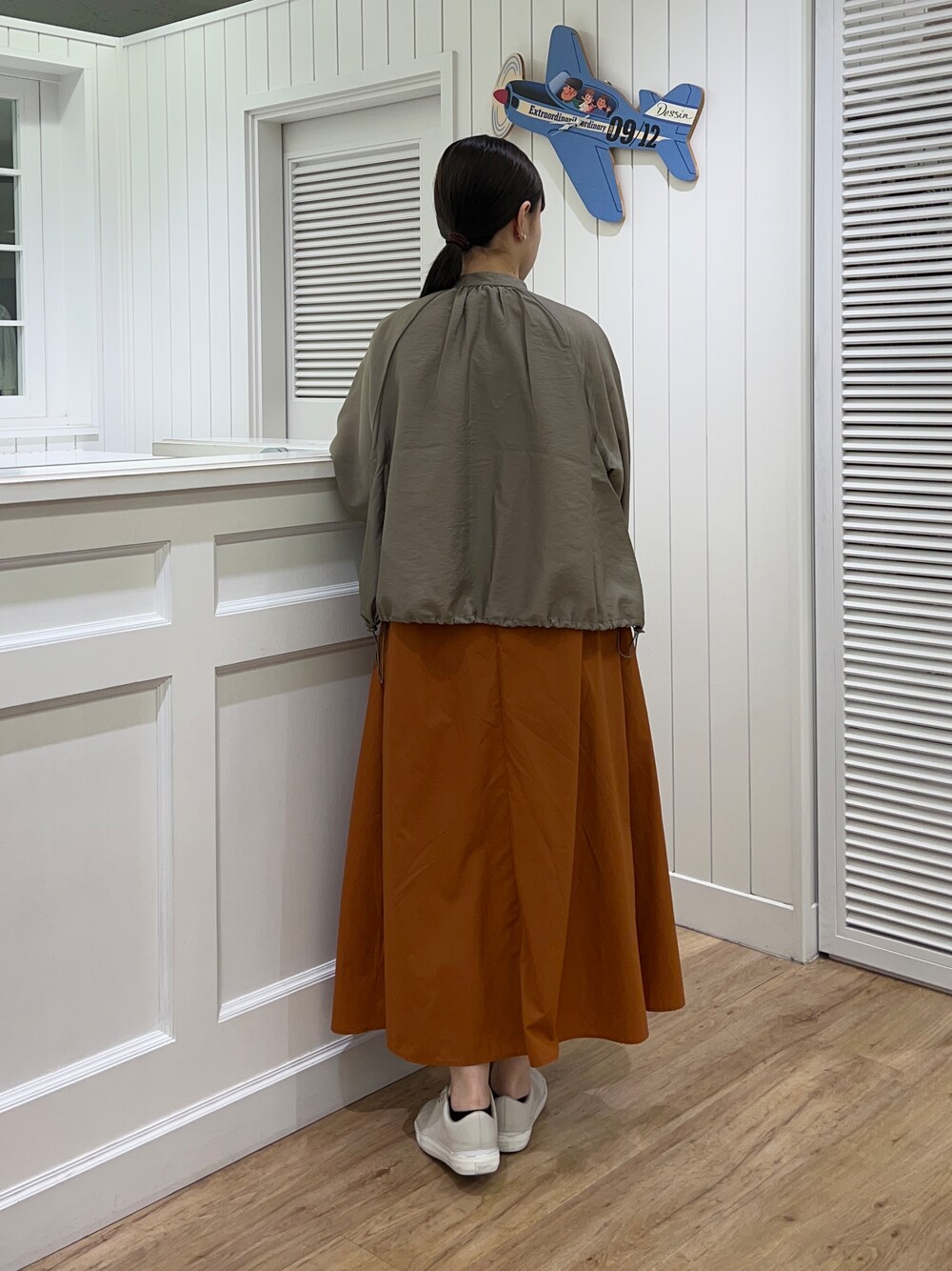 グリーン系のブルゾン、イエロー系のワンピース、イエロー系のトートバッグを着用したレディースの夏コーディネートの3枚目の写真