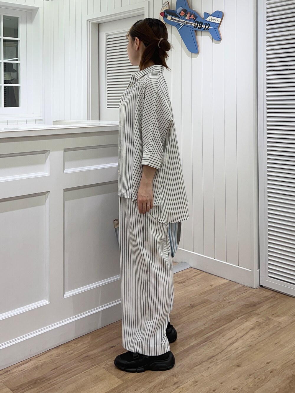 ホワイト系のシャツ/ブラウス、ホワイト系のその他パンツ、ブラック系のサンダルを着用したレディースの春コーディネートの2枚目の写真