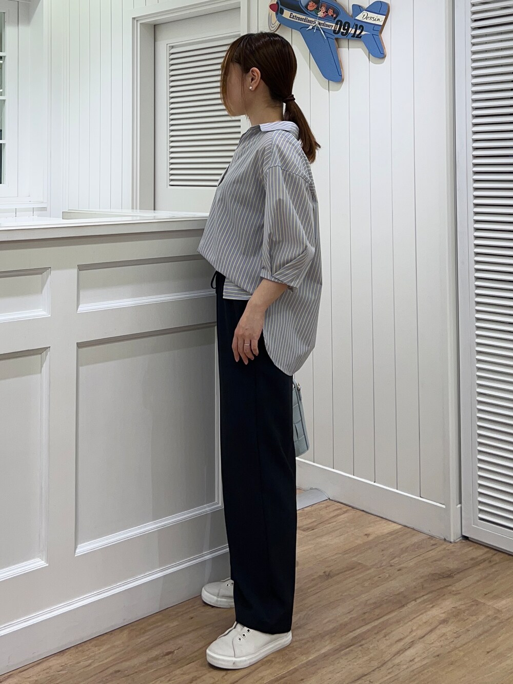 イエロー系のシャツ/ブラウス、ブルー系のその他パンツ、ブルー系のショルダーバッグを着用したレディースの春コーディネートの2枚目の写真