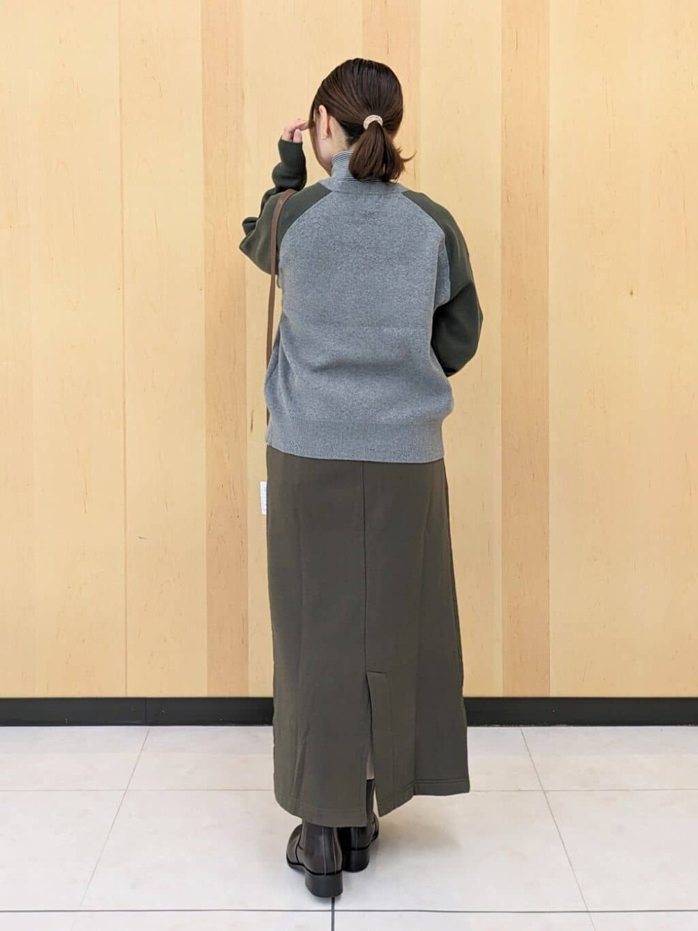 ブラック系のTシャツ/カットソー、グリーン系のニット/セーター、グリーン系のスカートを着用したレディースの秋コーディネートの3枚目の写真