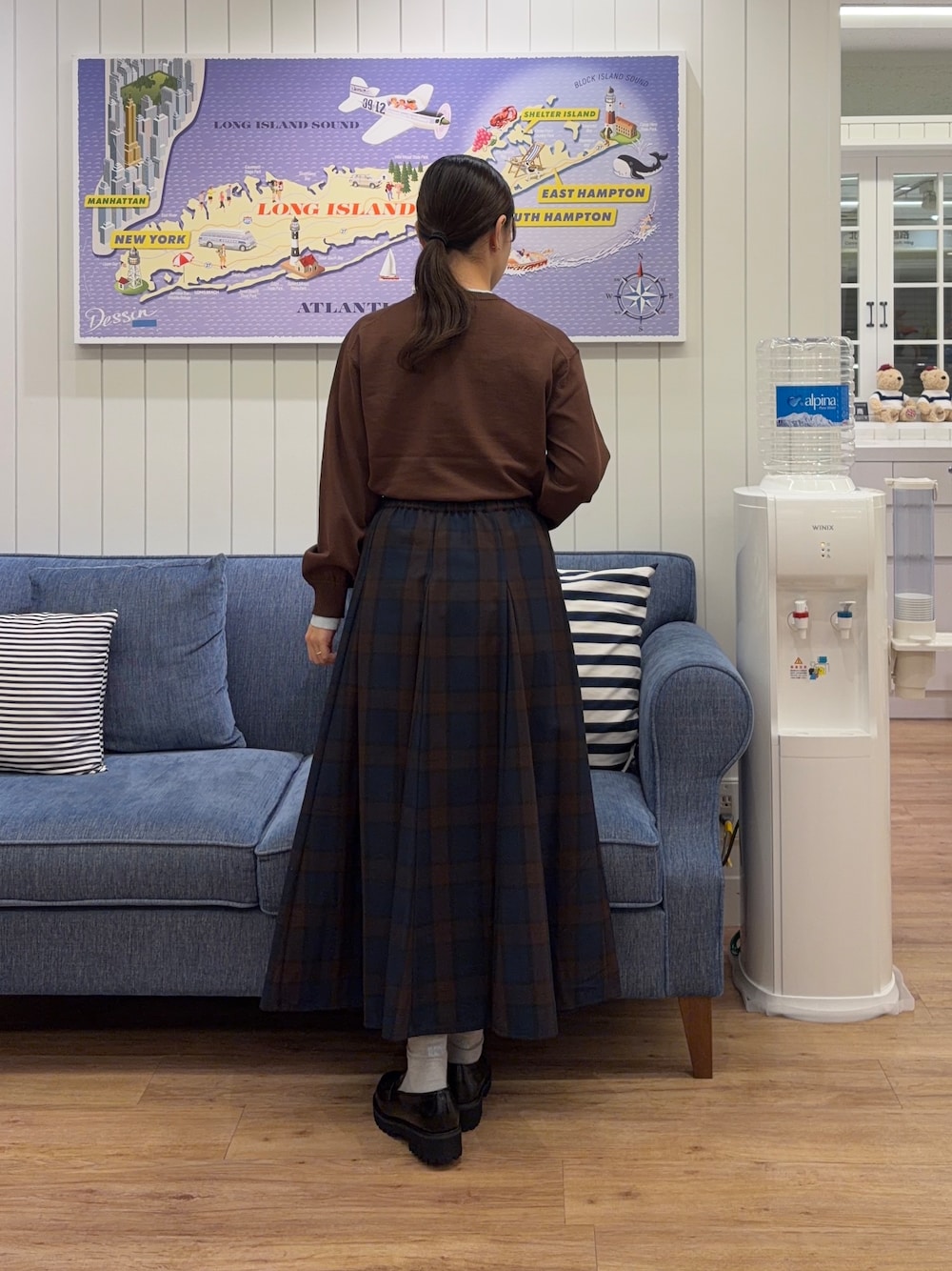 ブラウン系のニット/セーター、ブルー系のスカート、イエロー系のトートバッグを着用したレディースの秋コーディネートの3枚目の写真