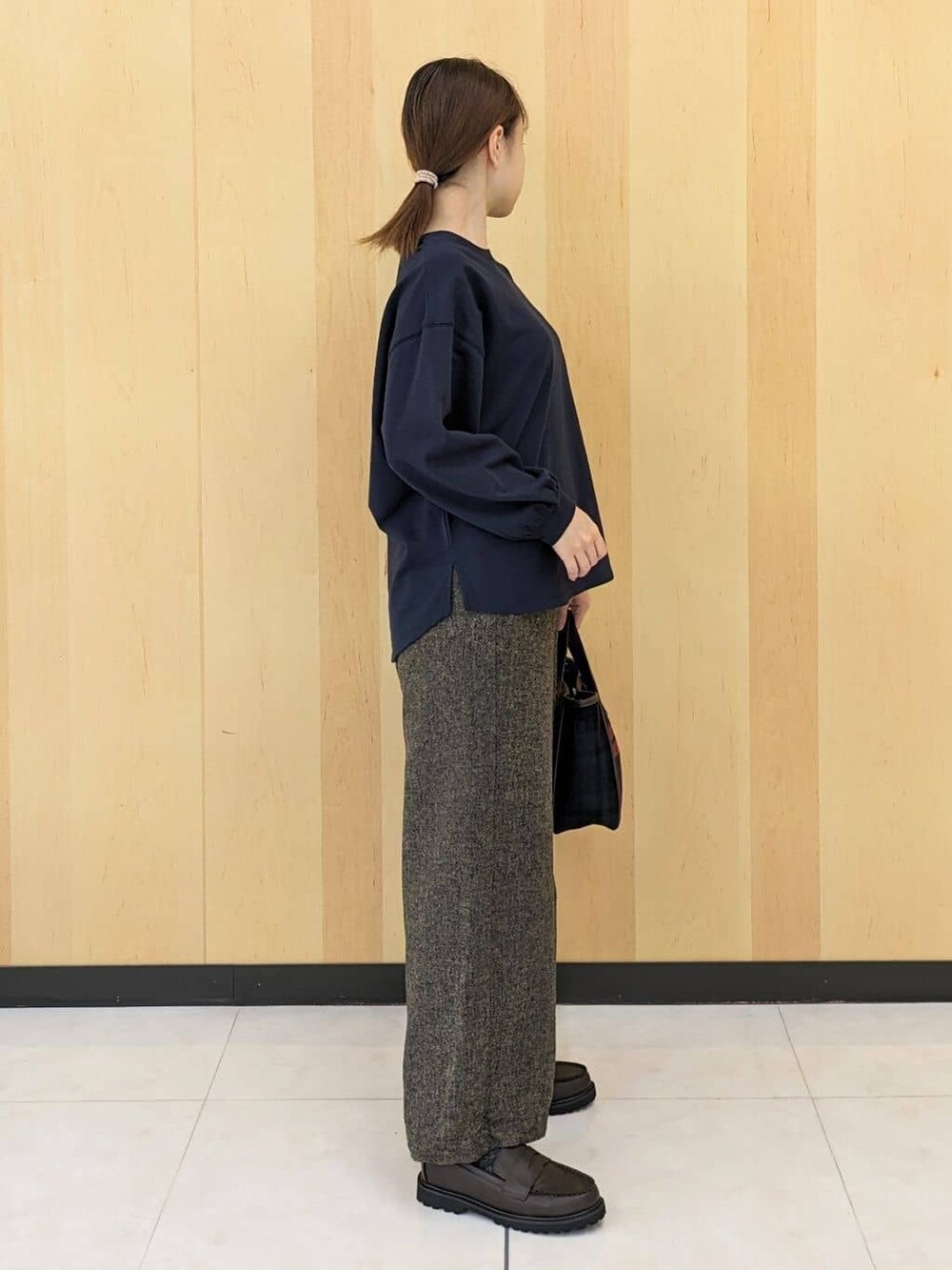 ブルー系のTシャツ/カットソー、ブラウン系のその他パンツ、レッド系のトートバッグを着用したレディースの秋コーディネートの2枚目の写真