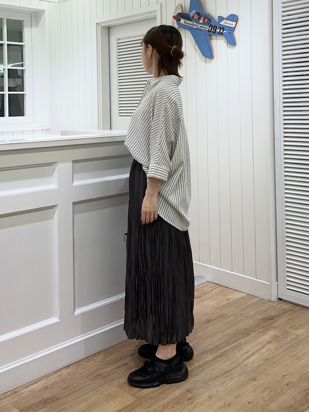ホワイト系のシャツ/ブラウス、グレー系のスカート、ブラック系のサンダルを着用したレディースの春コーディネートの2枚目の写真