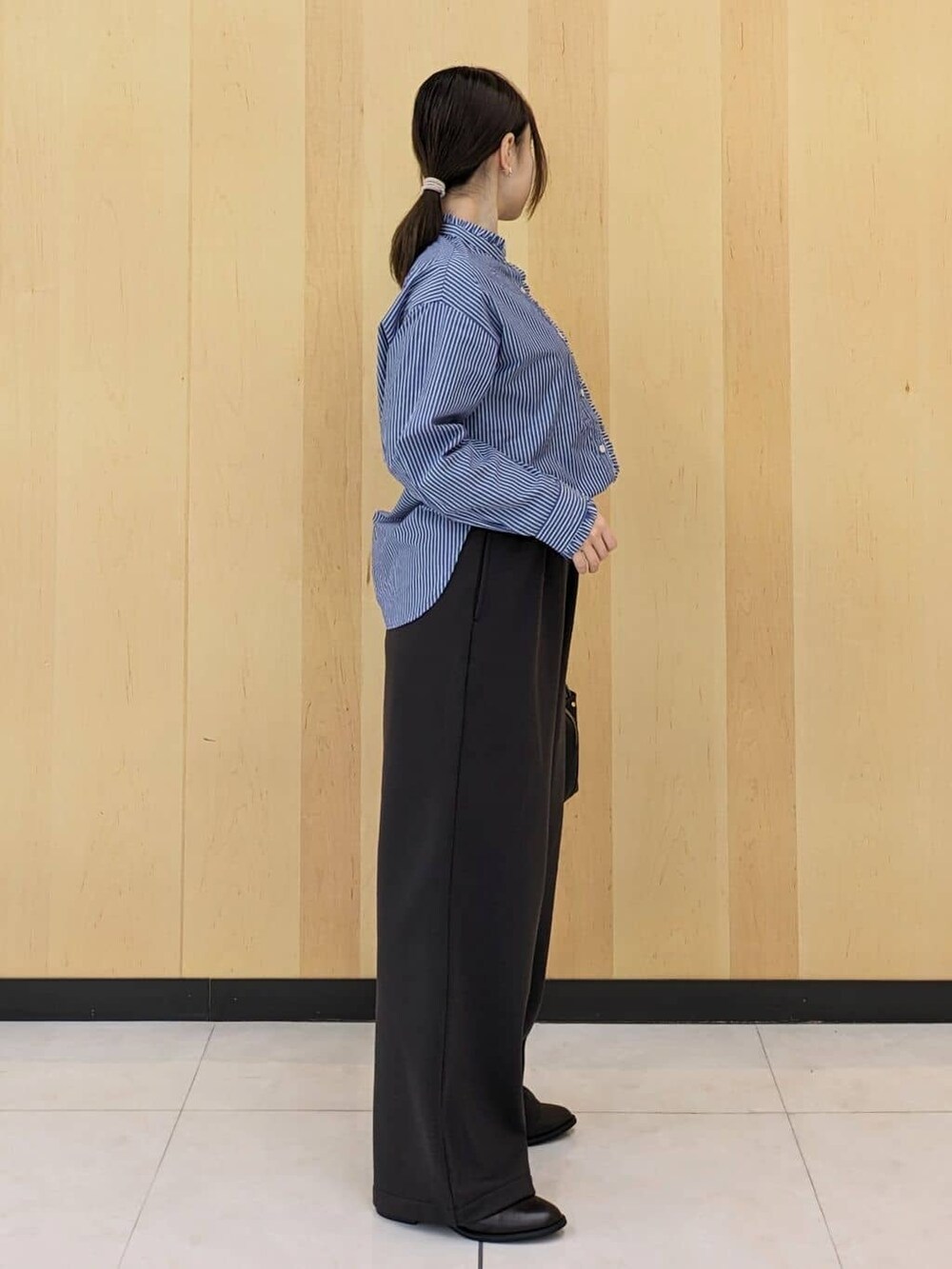 ブルー系のシャツ/ブラウス、ブラウン系のその他パンツ、ブラック系のショルダーバッグを着用したレディースの冬コーディネートの2枚目の写真