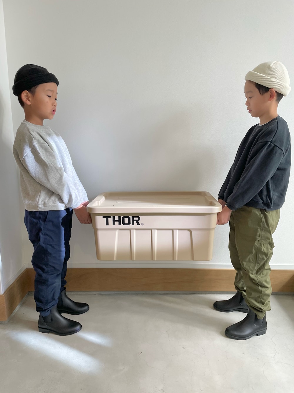 ブラック系のレインシューズ、ブルー系のパンツ、ホワイト系のニットキャップ/ビーニーを着用したキッズの冬コーディネートの2枚目の写真