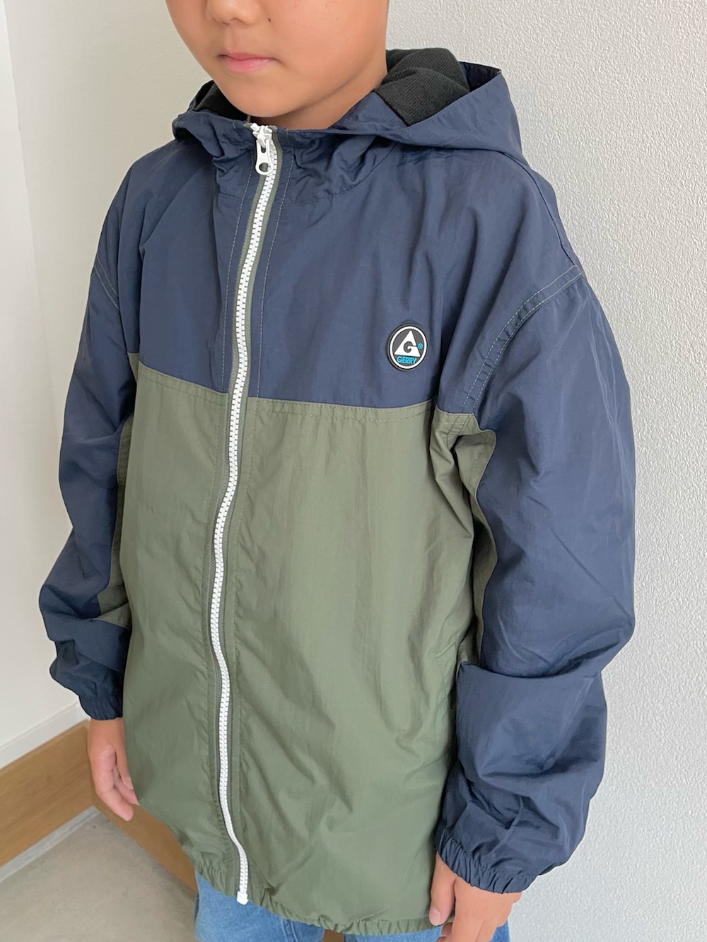 ベージュ系のマウンテンパーカー、グリーン系のマウンテンパーカー、グレー系のその他パンツを着用したキッズの秋コーディネートの3枚目の写真