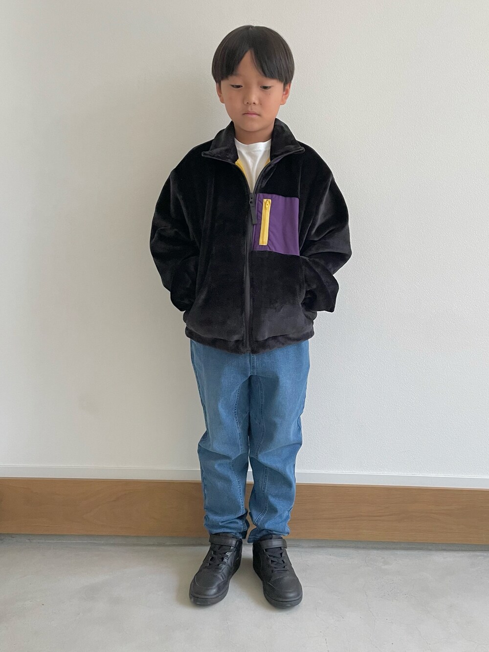 ブラック系のブルゾン、ベージュ系のブルゾン、グレー系のその他パンツを着用したキッズの秋コーディネートの2枚目の写真