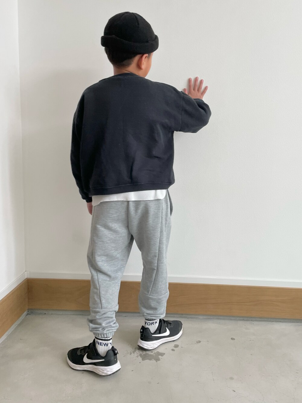グレー系のスウェットパンツ、ブラック系のスウェット、ブラック系のスニーカーを着用したキッズの冬コーディネートの2枚目の写真