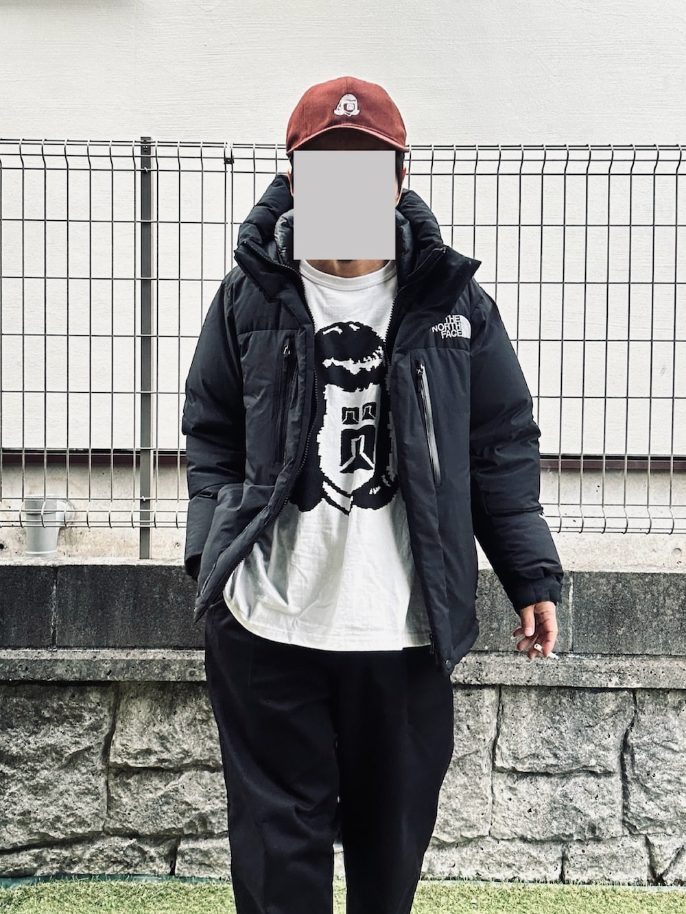 ブラック系のダウンジャケット/コート、ホワイト系のスニーカー、ホワイト系のTシャツ/カットソーを着用したメンズの冬コーディネートの2枚目の写真