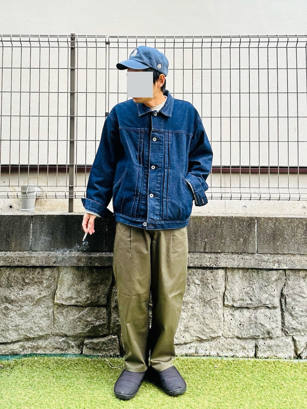 ブラック系のスリッポン、グリーン系のチノパンツ、ブルー系のデニムジャケットを着用したメンズの冬コーディネートの2枚目の写真