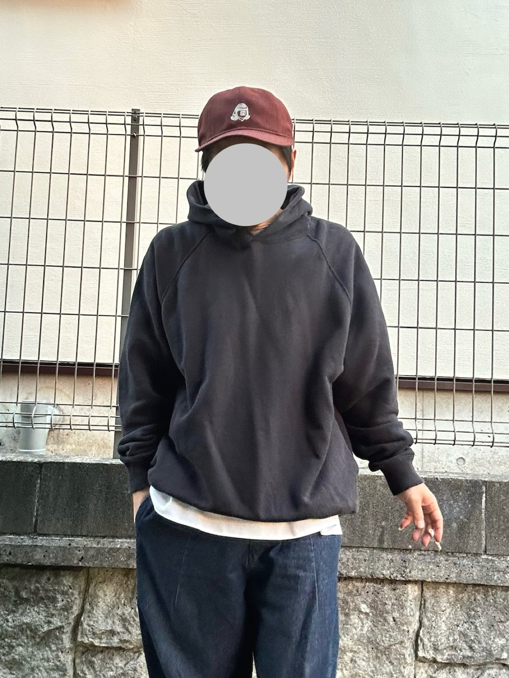 ホワイト系のスニーカー、ブラック系のパーカー、ブルー系のデニムパンツを着用したメンズの冬コーディネートの2枚目の写真
