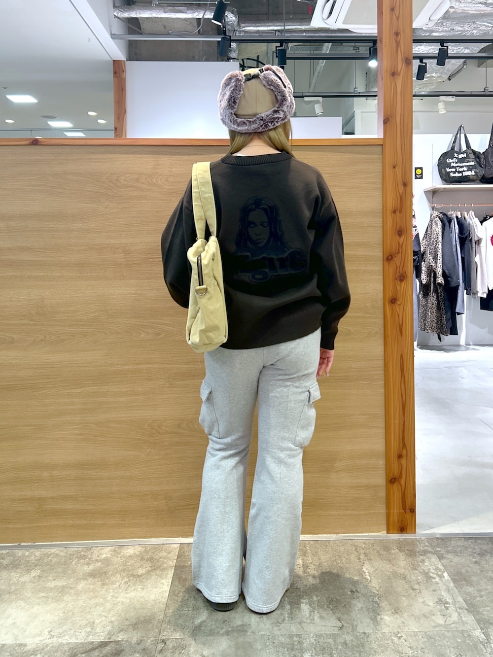 グレー系のニット/セーター、グレー系のスウェットパンツ、ベージュ系のトートバッグを着用したレディースの秋コーディネートの2枚目の写真