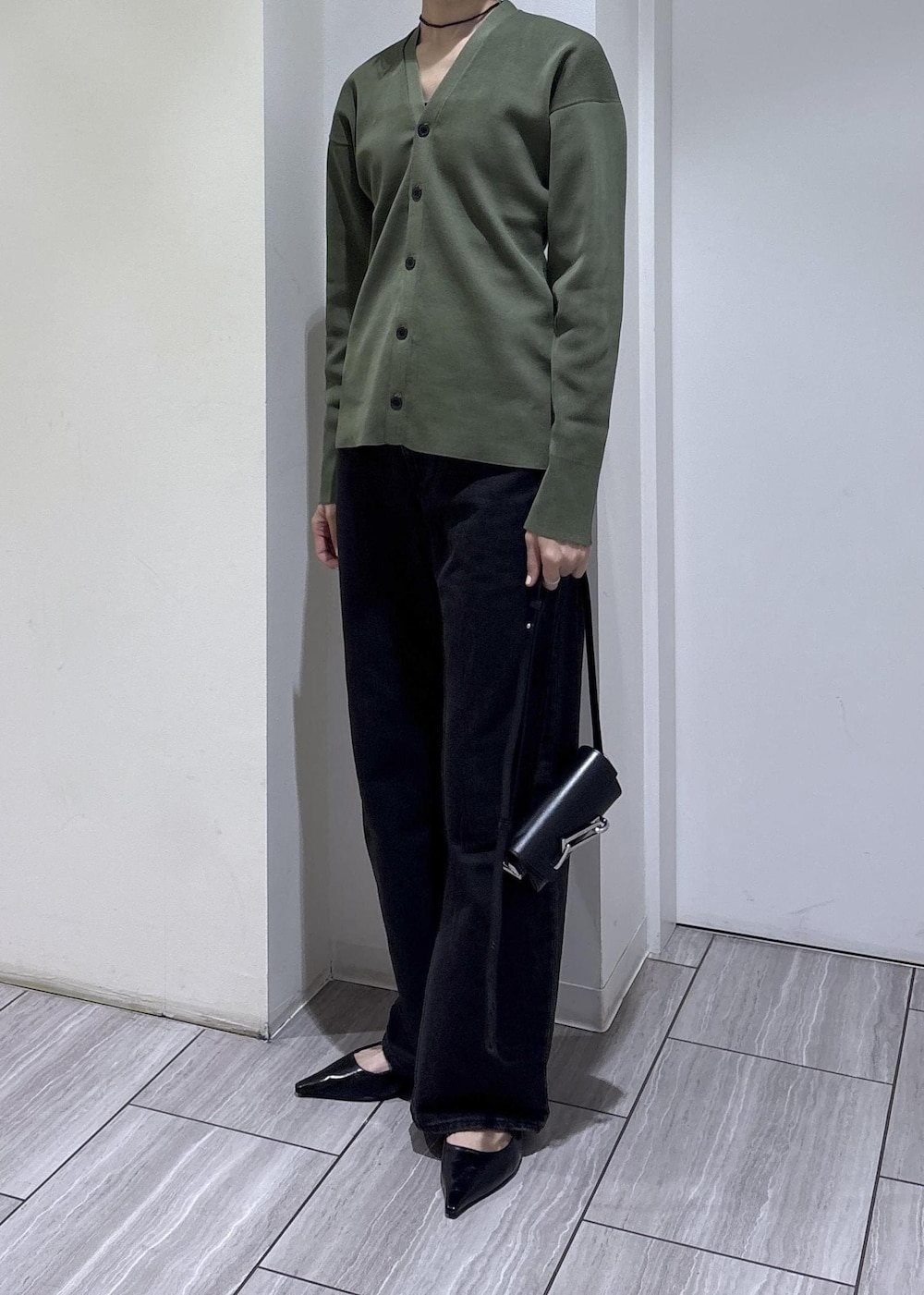 ブラック系のパンプス、ブラック系のショルダーバッグを着用したレディースの春コーディネートの3枚目の写真