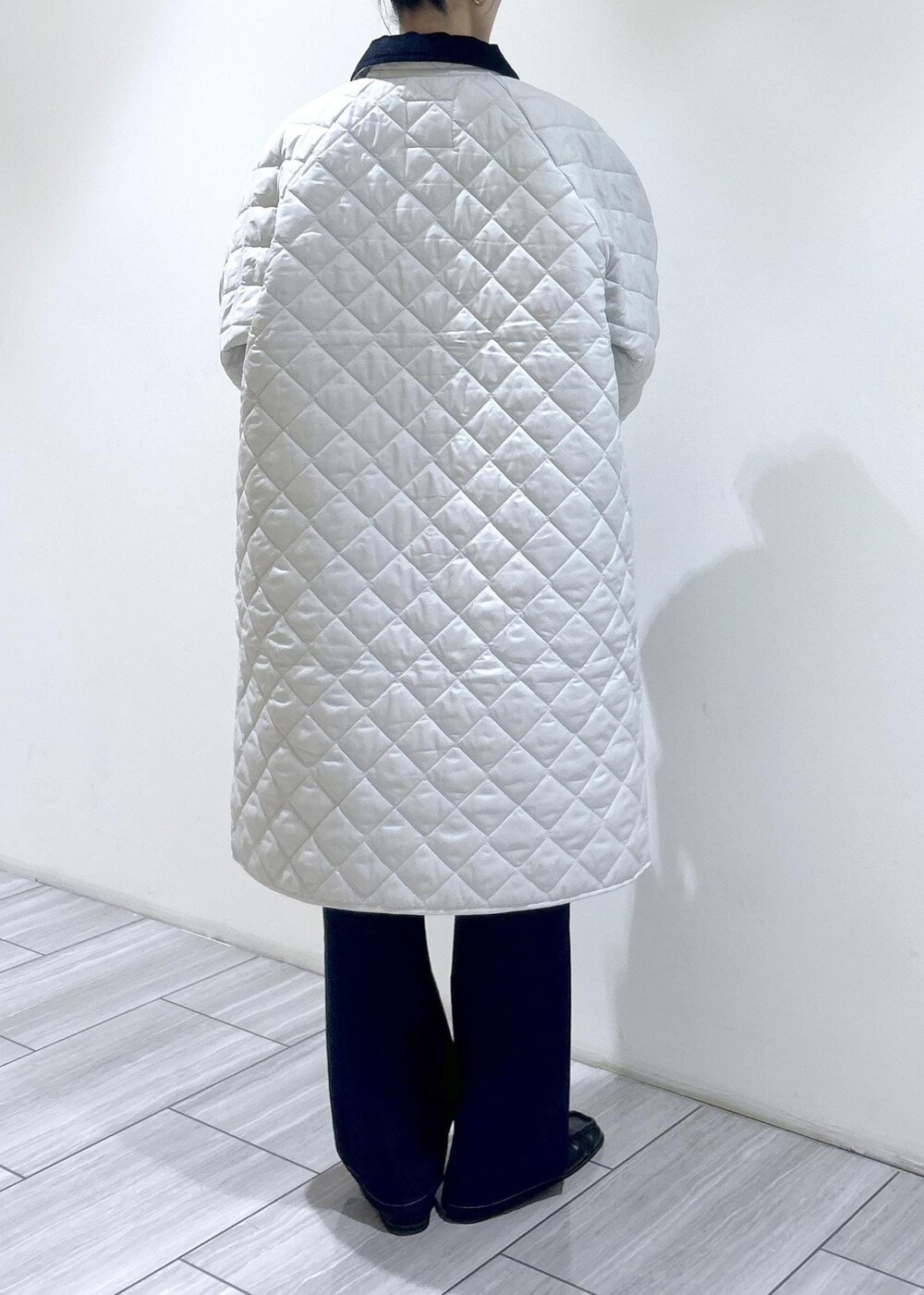 ホワイト系のナイロンジャケット、ブラック系のデニムパンツ、ブラウン系のローファーを着用したレディースの秋コーディネートの4枚目の写真