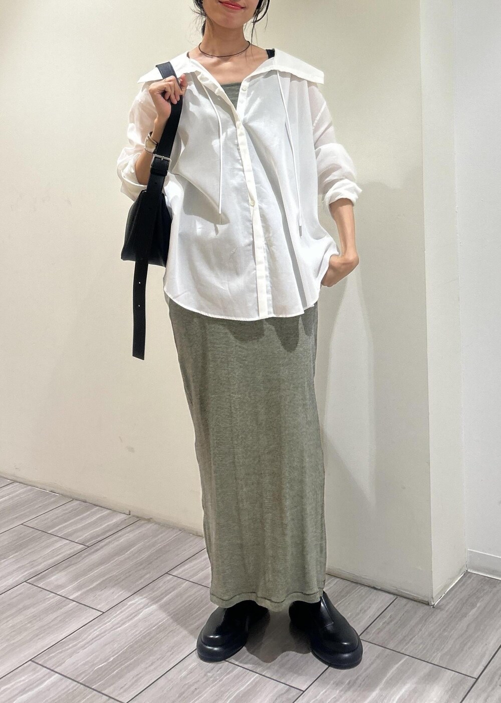 ホワイト系のシャツ/ブラウス、グリーン系のタンクトップ、グリーン系のスカートを着用したレディースの春コーディネートの6枚目の写真
