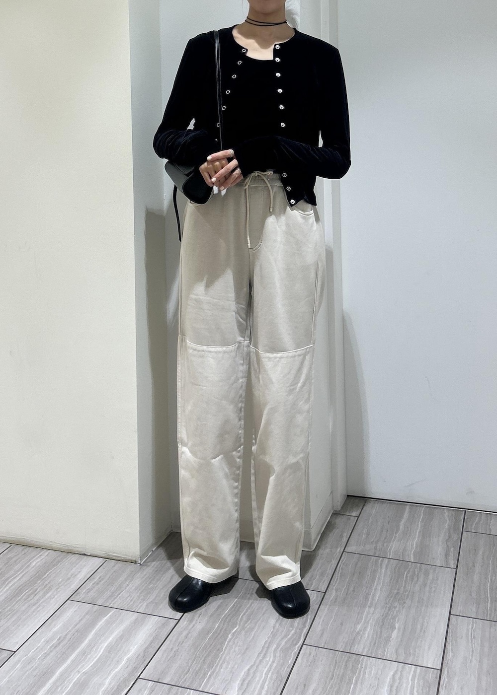 ブラック系のブーツ、ブラック系のカーディガン/ボレロ、ブラック系のショルダーバッグを着用したレディースの秋コーディネートの2枚目の写真