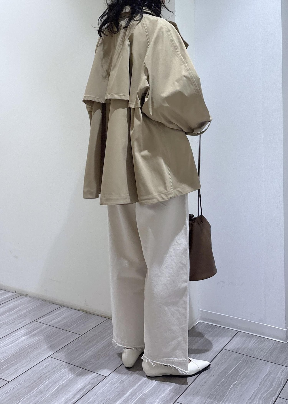 ホワイト系のパンプス、グレー系のTシャツ/カットソー、ベージュ系のトレンチコートを着用したレディースの冬コーディネートの4枚目の写真