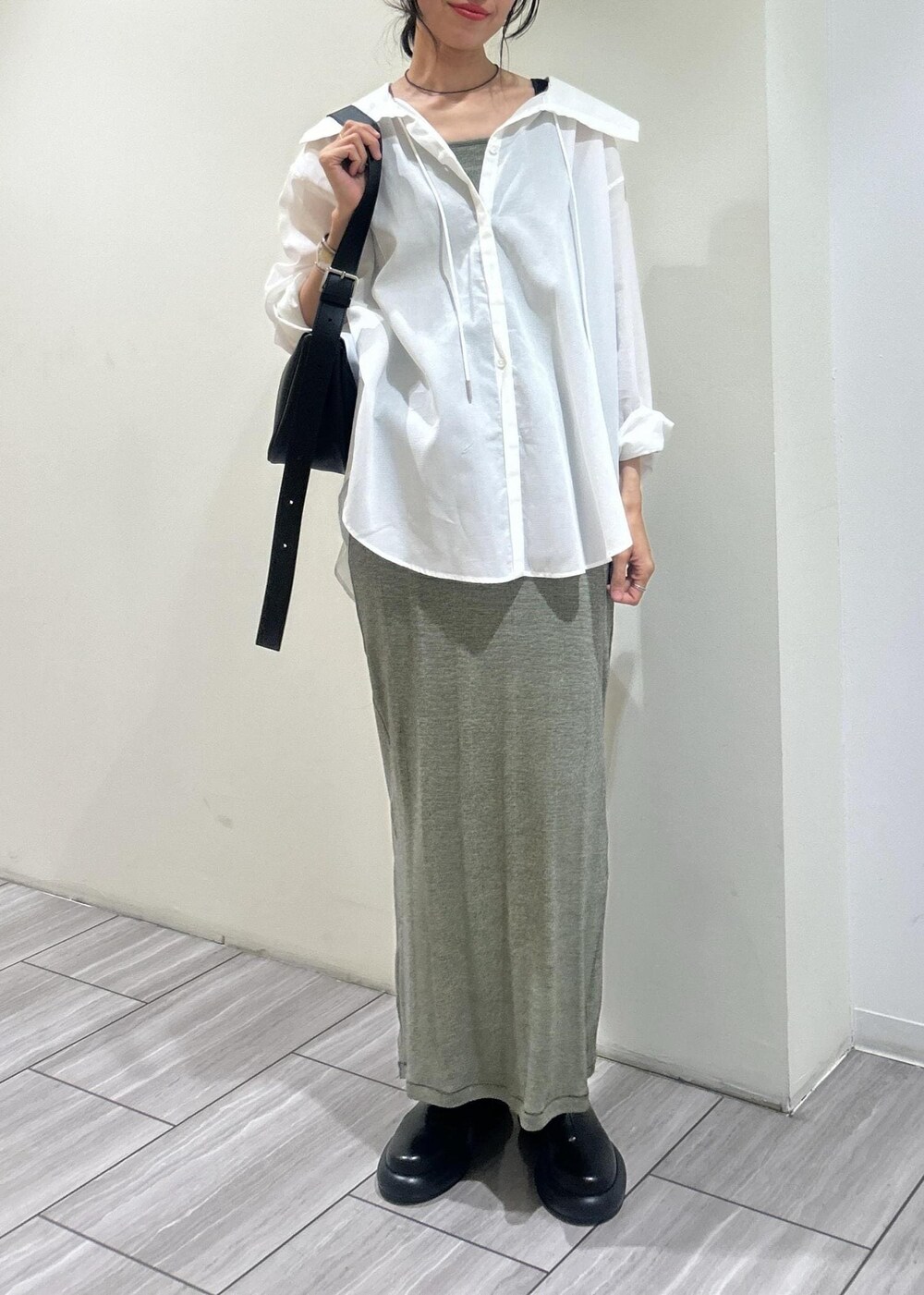 ホワイト系のシャツ/ブラウス、グリーン系のタンクトップ、グリーン系のスカートを着用したレディースの春コーディネートの7枚目の写真