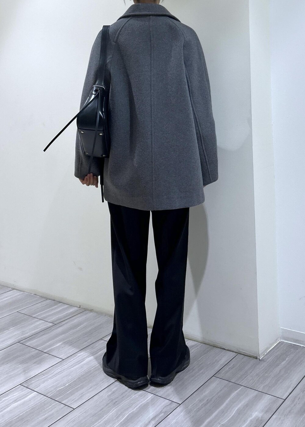 ブラック系のスウェット、ブラック系のショルダーバッグ、グレー系のステンカラーコートを着用したレディースの秋コーディネートの5枚目の写真