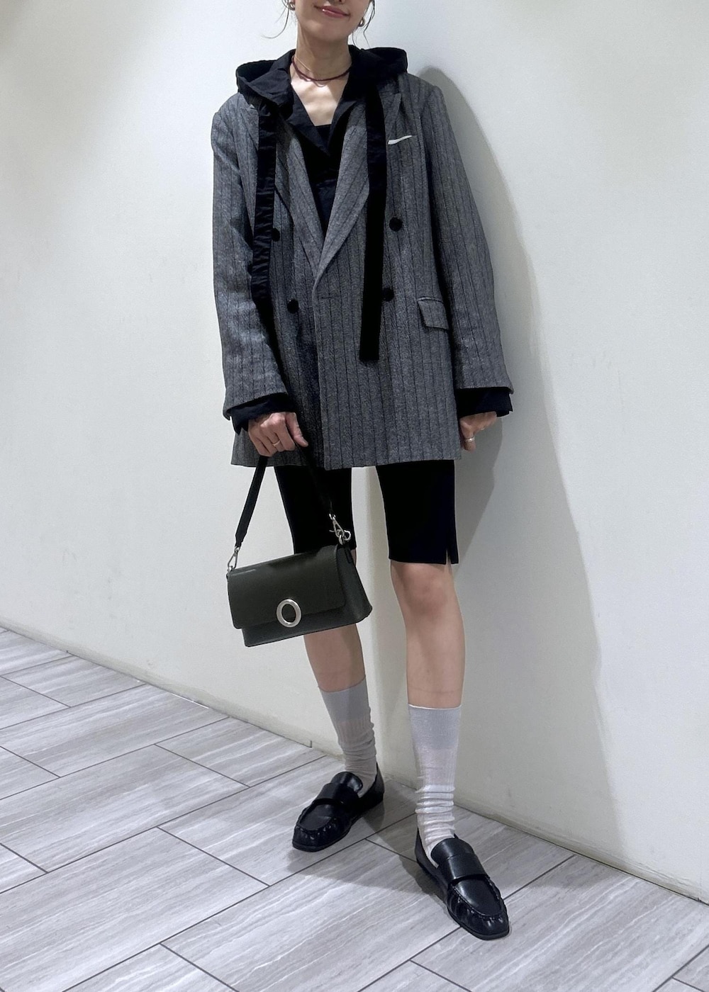 ブラック系のその他パンツ、ブラック系のシャツ/ブラウス、グレー系のテーラードジャケットを着用したレディースの秋コーディネートの6枚目の写真