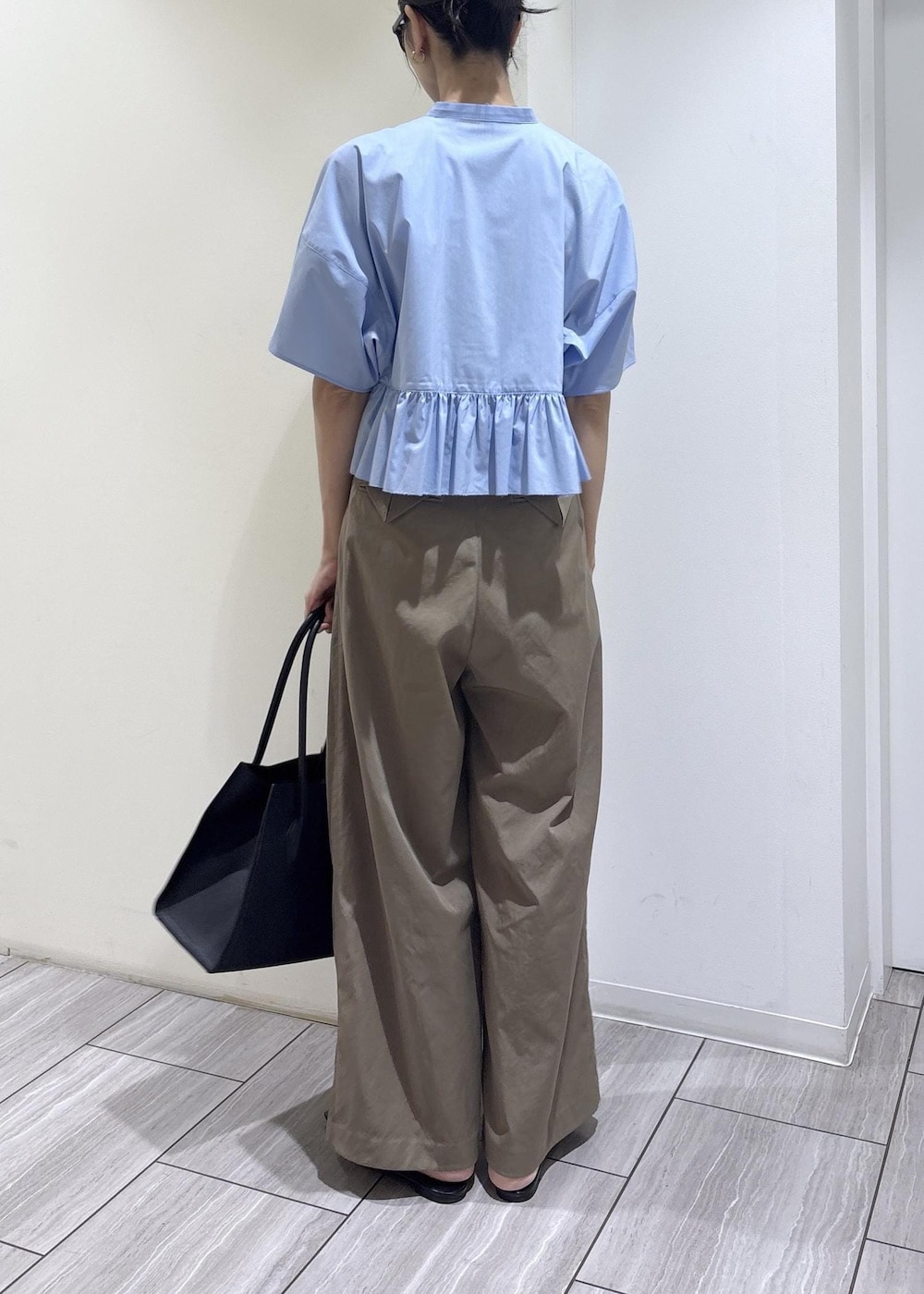 ブラック系のパンプス、ブルー系のシャツ/ブラウス、グリーン系のその他パンツを着用したレディースの春コーディネートの3枚目の写真