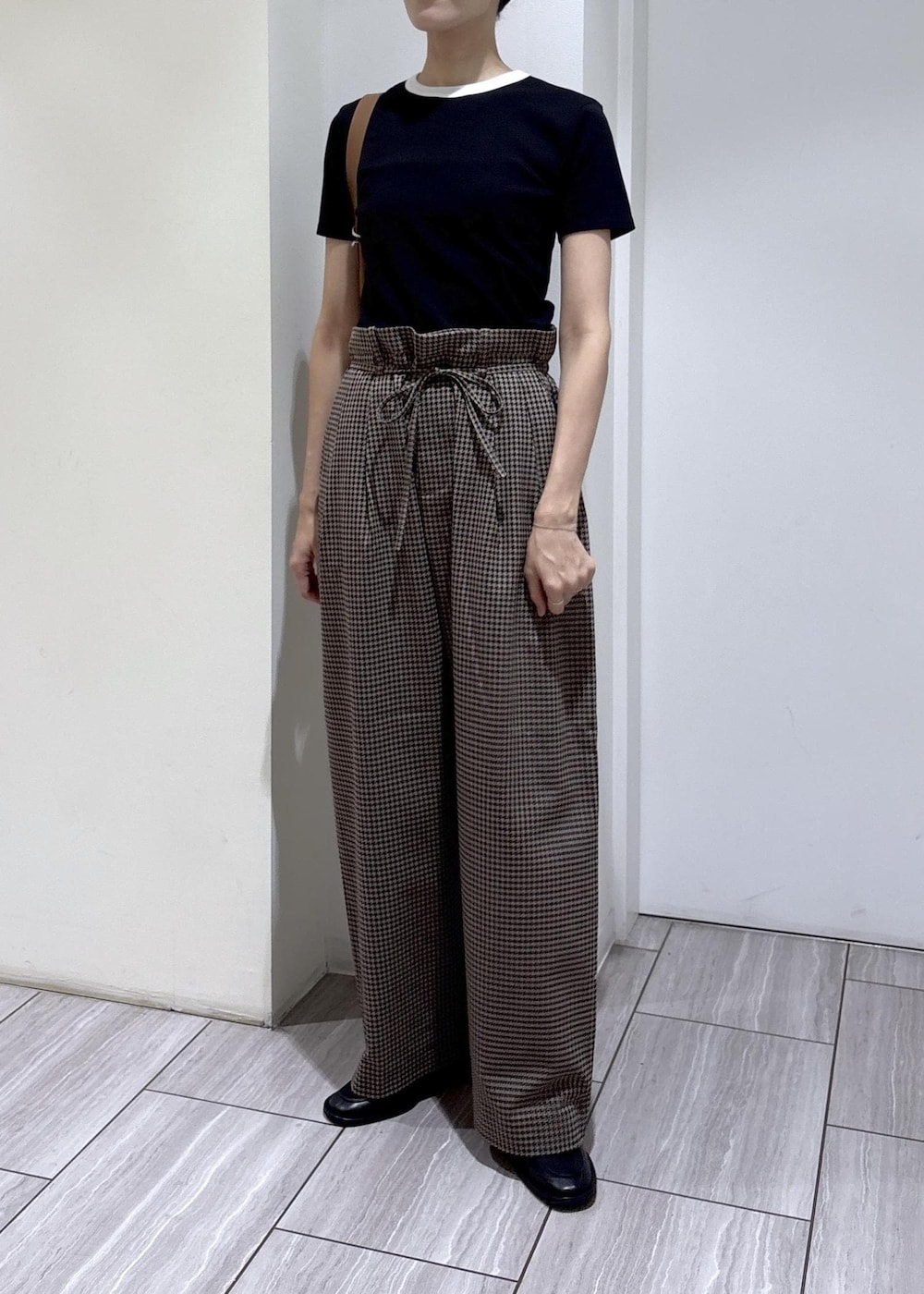 ブラック系のローファー、ブラウン系のスラックス、ブラック系のTシャツ/カットソーを着用したレディースの夏コーディネートの2枚目の写真