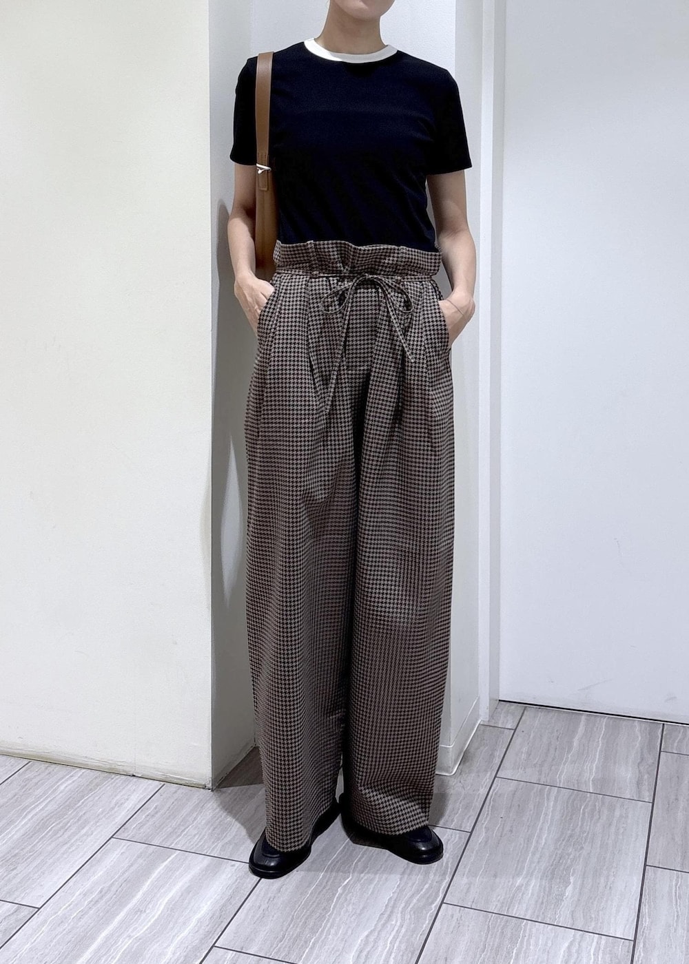 ブラック系のローファー、ブラウン系のスラックス、ブラック系のTシャツ/カットソーを着用したレディースの夏コーディネートの6枚目の写真