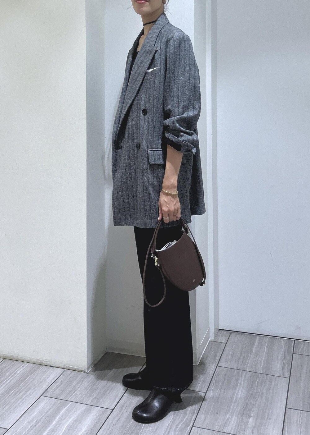 ブラック系のキャミソール、グレー系のテーラードジャケット、ブラウン系のブーツを着用したレディースの秋コーディネートの4枚目の写真