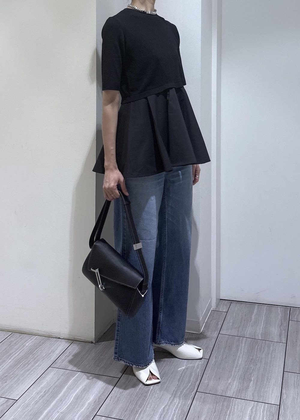 ホワイト系のサンダル、ブラック系のニット/セーター、ブルー系のデニムパンツを着用したレディースの春コーディネートの7枚目の写真