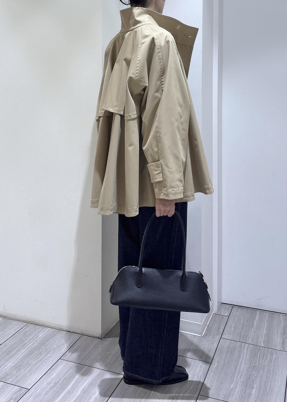 ブラック系のバレエシューズ、ブラック系のボストンバッグ、ベージュ系のトレンチコートを着用したレディースの春コーディネートの6枚目の写真