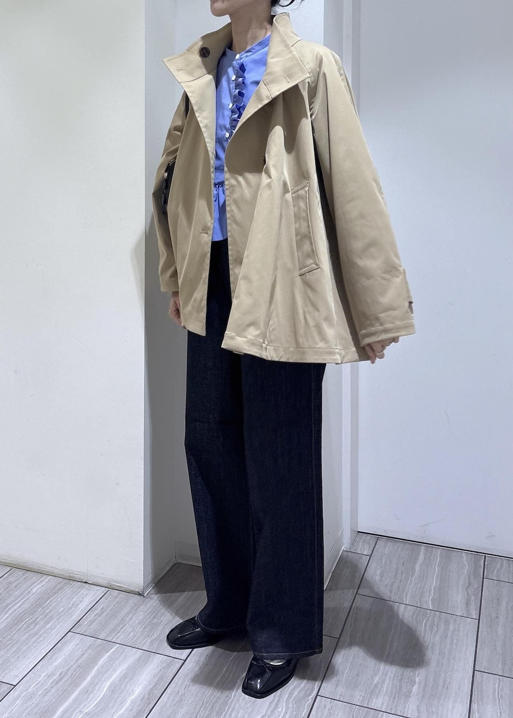 ブラック系のバレエシューズ、ブラック系のボストンバッグ、ベージュ系のトレンチコートを着用したレディースの春コーディネートの3枚目の写真