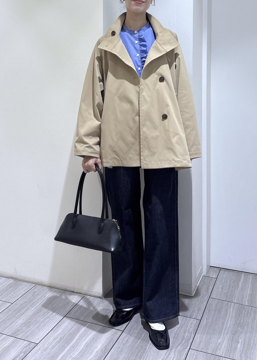 ブラック系のバレエシューズ、ブラック系のボストンバッグ、ベージュ系のトレンチコートを着用したレディースの春コーディネートの7枚目の写真