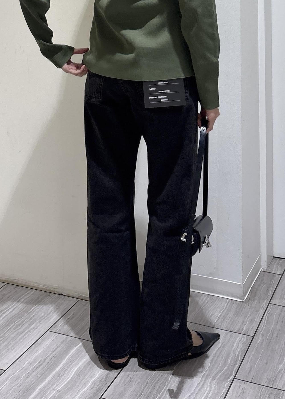 ブラック系のパンプス、ブラック系のショルダーバッグを着用したレディースの春コーディネートの6枚目の写真