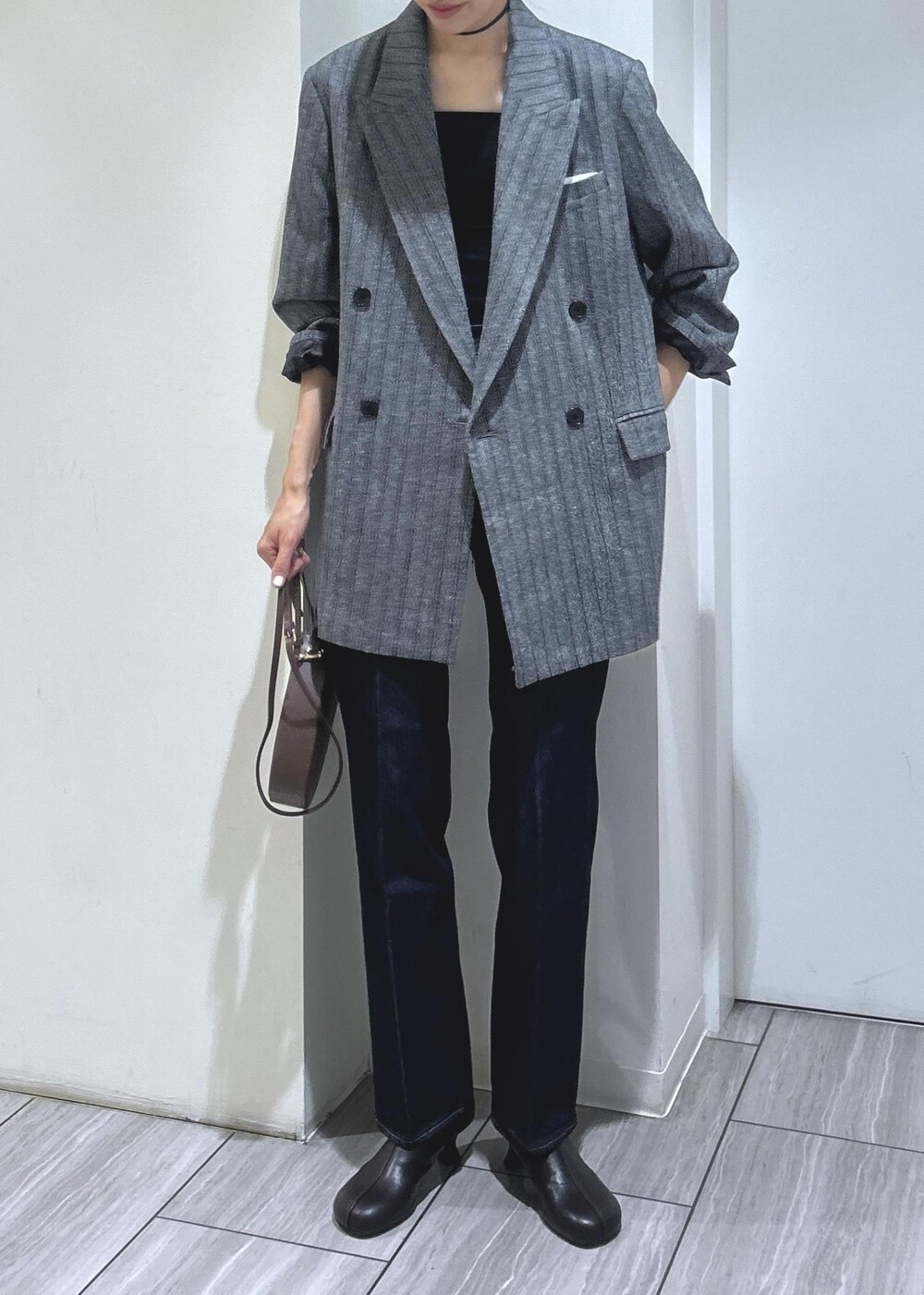 ブラック系のキャミソール、グレー系のテーラードジャケット、ブラウン系のブーツを着用したレディースの秋コーディネートの7枚目の写真