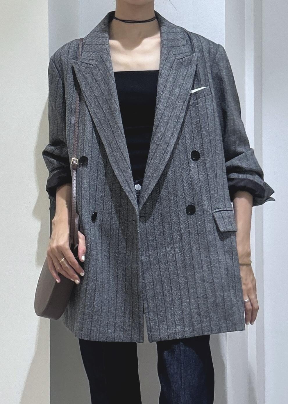 ブラック系のキャミソール、グレー系のテーラードジャケット、ブラウン系のブーツを着用したレディースの秋コーディネートの3枚目の写真