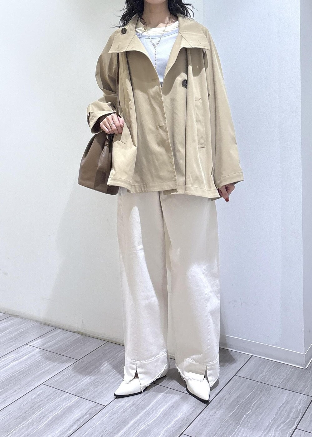 ホワイト系のパンプス、グレー系のTシャツ/カットソー、ベージュ系のトレンチコートを着用したレディースの冬コーディネートの6枚目の写真