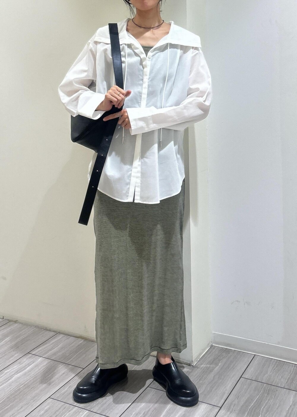 ホワイト系のシャツ/ブラウス、グリーン系のタンクトップ、グリーン系のスカートを着用したレディースの春コーディネートの2枚目の写真