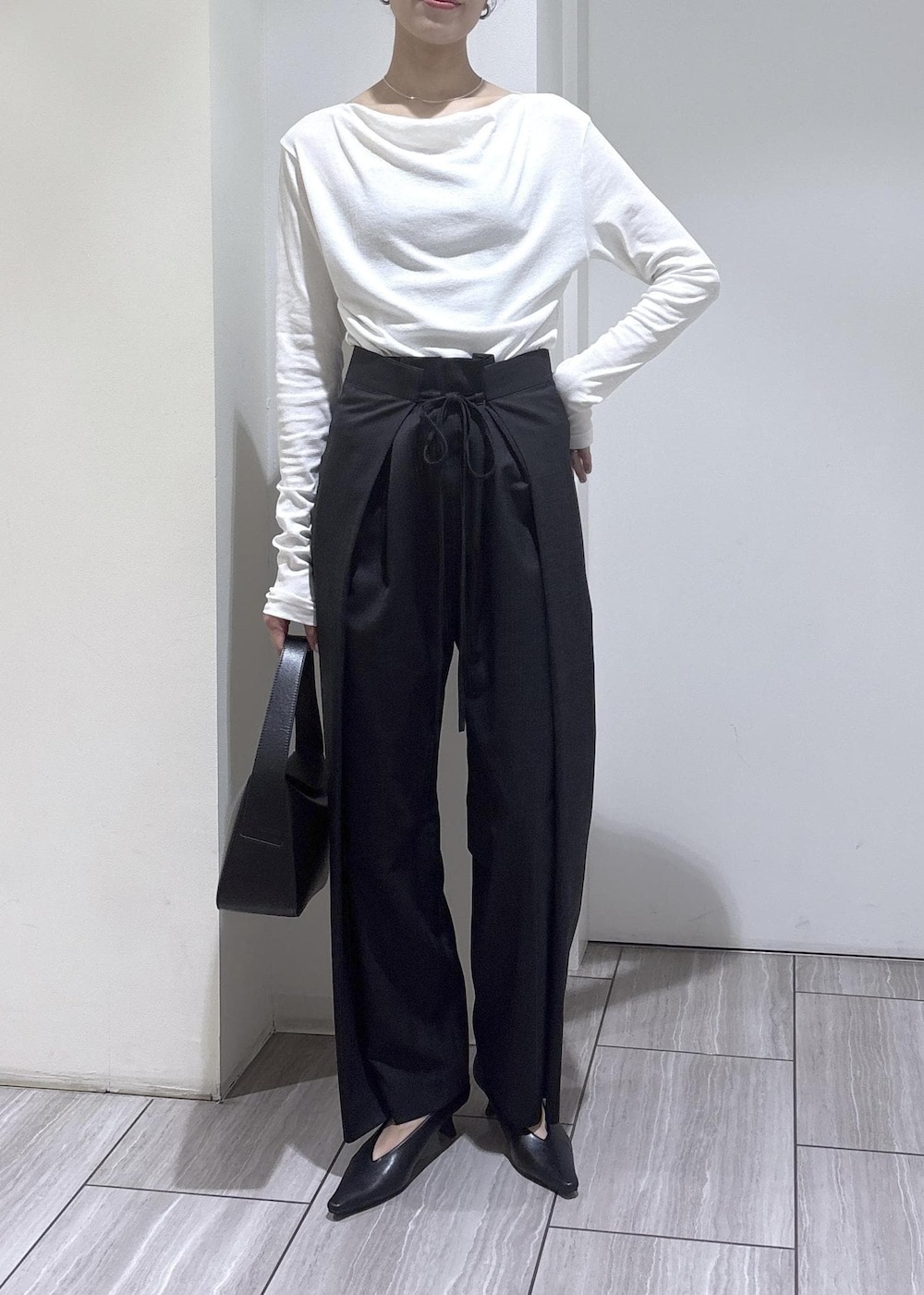 ブラック系のショルダーバッグ、ブラック系のパンプス、ホワイト系のTシャツ/カットソーを着用したレディースの夏コーディネートの7枚目の写真